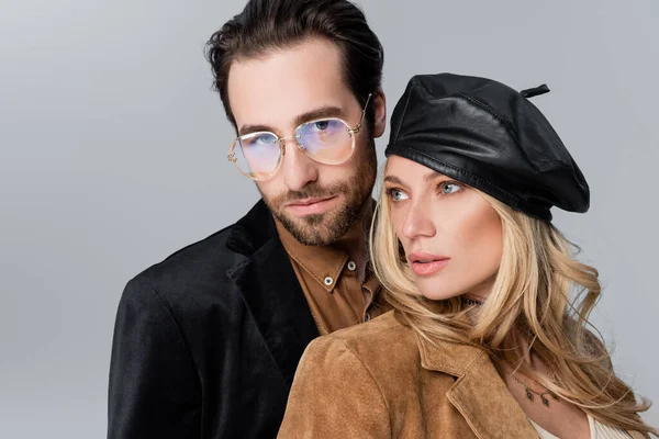 Blonde woman in stylish beret near bearded man in sunglasses looking at camera isolated on grey — Foto stock