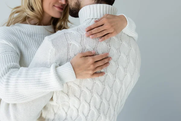 Cropped view of cheerful woman in white sweater hugging with boyfriend isolated on grey - foto de stock