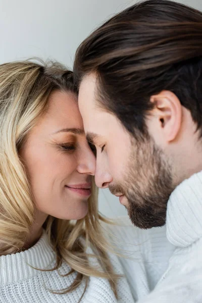 Close up of happy couple with closed eyes standing face to face isolated on grey — Foto stock