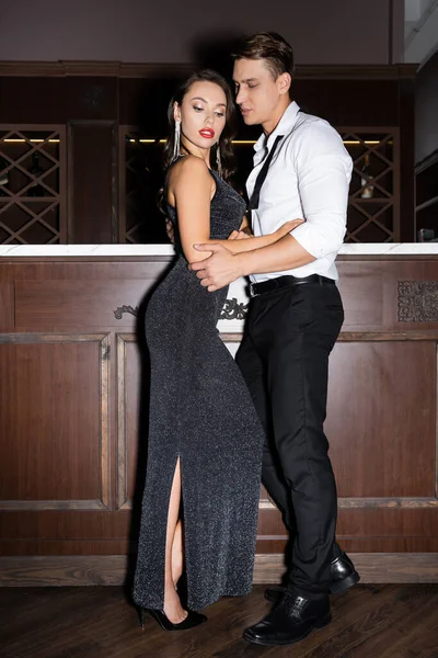 Elegant man touching girlfriend in dress near bar — Stock Photo