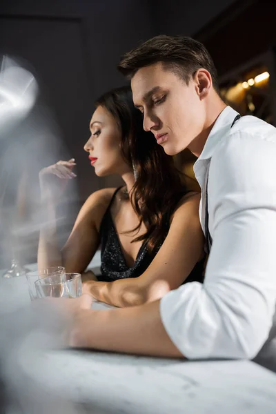 Man in shirt holding glass near elegant girlfriend in bar — Foto stock