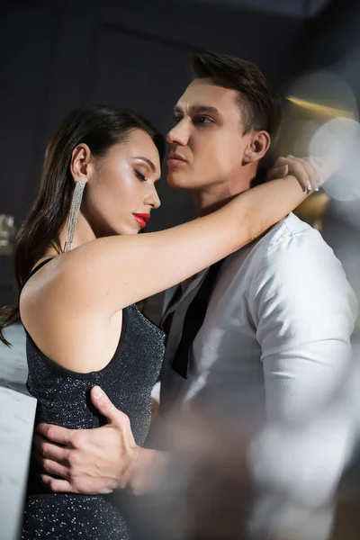 Elegant woman in dress embracing boyfriend in shirt at home in evening — Stock Photo