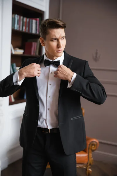 Elegant man in suit wearing jacket at home — Stock Photo