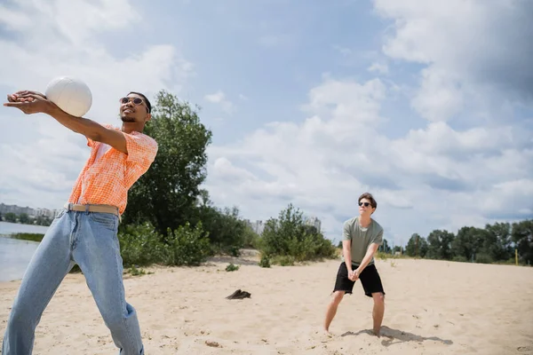 Young african american man playing beach volleyball with friend — Stock Photo