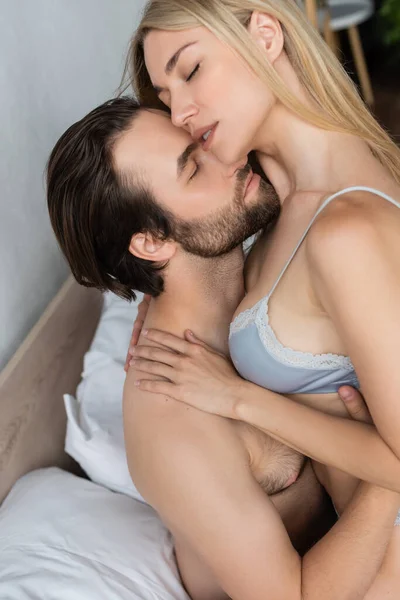 High angle view of passionate couple with closed eyes embracing in bedroom — Foto stock