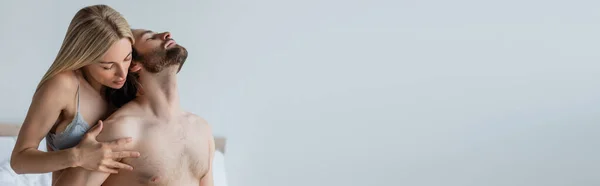 Hot woman in sexy underwear hugging shirtless man in bedroom, banner — Stock Photo