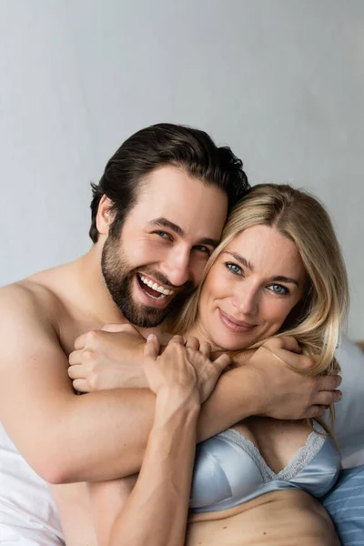 Cheerful and sexy couple smiling while looking at camera — Stock Photo