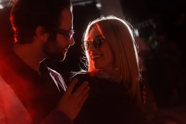 Young man hugging cheerful girlfriend in sunglasses during party — Stock Photo