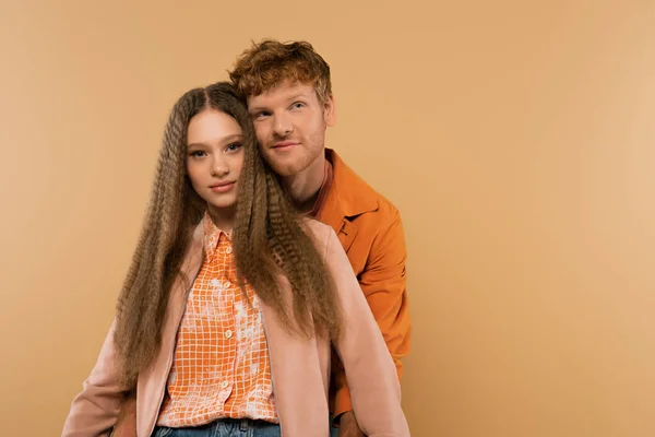 Joyful young man with red hair near smiling girlfriend isolated on beige — Photo de stock