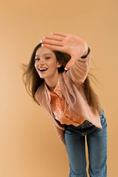 Збуджена дівчина-підліток в осінньому і повсякденному одязі, що показує стоп жест ізольований на бежевому — стокове фото