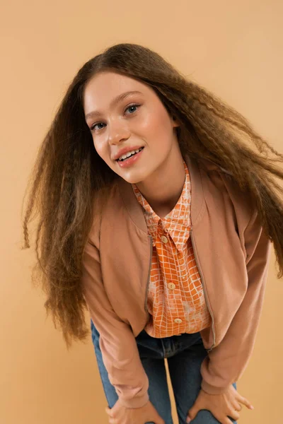 Cheerful teenage girl in autumnal and casual clothes posing isolated on beige — Stock Photo