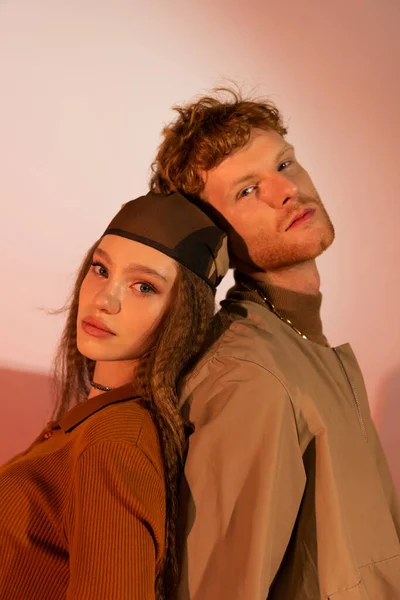 Teenage girl in headscarf standing back to back with boyfriend on red — Fotografia de Stock