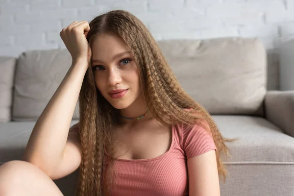 Portrait of teenage girl in casual clothes near blurred couch in modern living room — Stockfoto