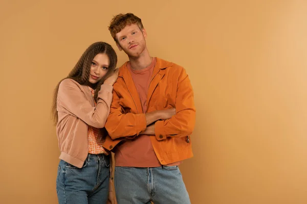 Redhead young man standing with crossed arms near girl isolated on beige — Fotografia de Stock