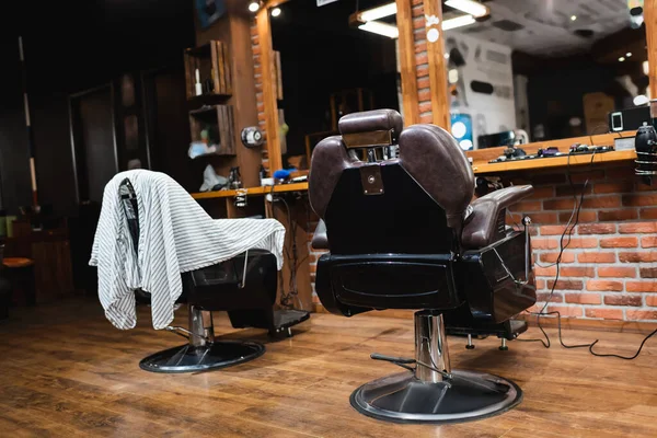 Poltronas de cabeleireiro confortáveis perto de espelhos na barbearia moderna — Fotografia de Stock