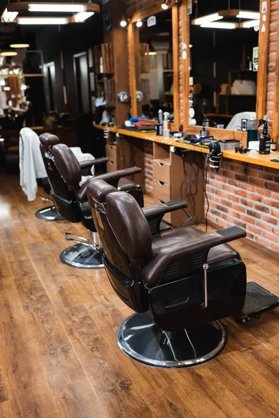 Comfortable armchairs near mirrors and hairdressing equipment in barbershop — Stock Photo