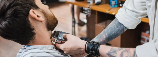 Tatoué coiffeur rasage cou de brune homme avec rasoir électrique, bannière — Photo de stock