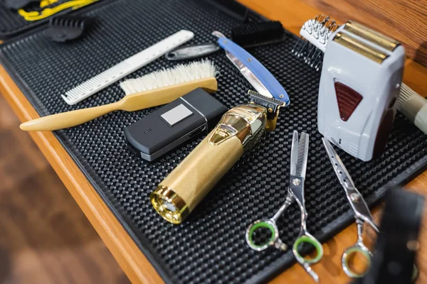 Electric shaving razors and hair clipper near hairdressing tools in beauty salon — Stock Photo