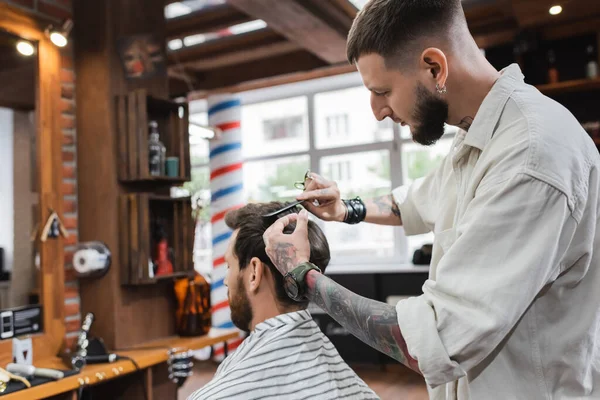 Peluquero barbudo corte de pelo de hombre en la barbería - foto de stock