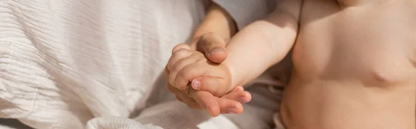 Vista recortada de la madre cogida de la mano con niña en el dormitorio, pancarta - foto de stock
