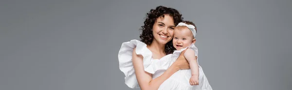 Felice madre in abito bianco abbraccio bambino figlia isolata su grigio, banner — Foto stock