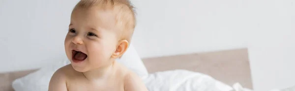 Alegre niña mirando hacia otro lado en la cama borrosa en casa, pancarta - foto de stock