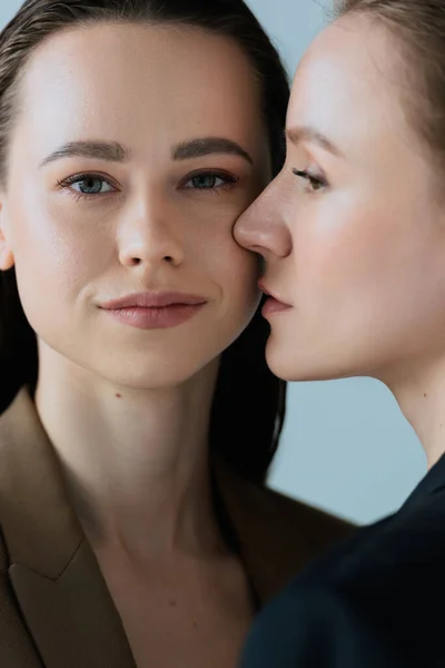 Souriant lesbienne femme regardant caméra près de jeune copine isolé sur gris — Photo de stock