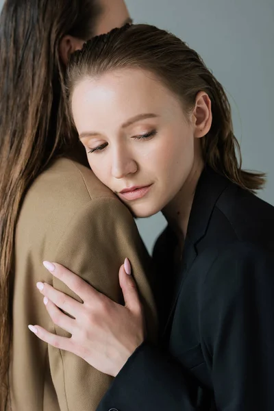 Tendre lesbienne femme penché sur lesbienne copine isolé sur gris — Stock Photo