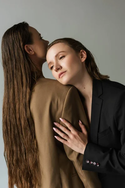 Sensual lésbicas mulher inclinado no longo cabelos namorada isolado no cinza — Fotografia de Stock