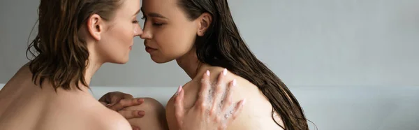 Young lesbian woman touching wet long haired girlfriend while taking bath together, banner — Stock Photo