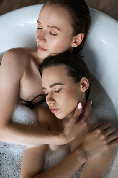 Vista superior da jovem mulher abraçando parceiro lésbico enquanto tomando banho juntos — Fotografia de Stock