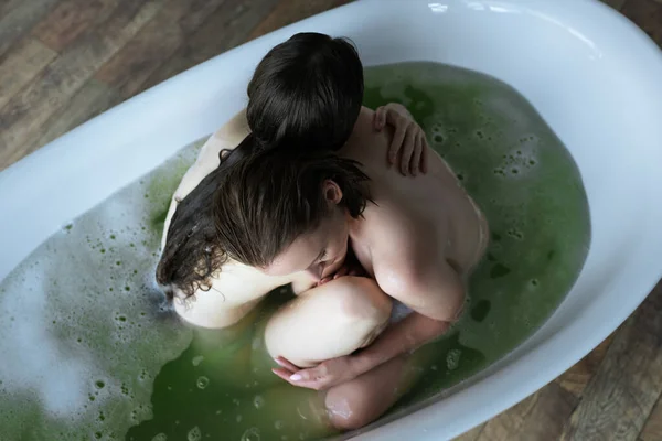 Vista superior de nuas lésbicas amantes abraçando na banheira em casa — Fotografia de Stock