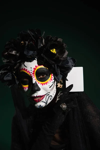 Портрет женщины в день смерти Хэллоуин костюм держатель карты изолированы на темно-зеленый — стоковое фото