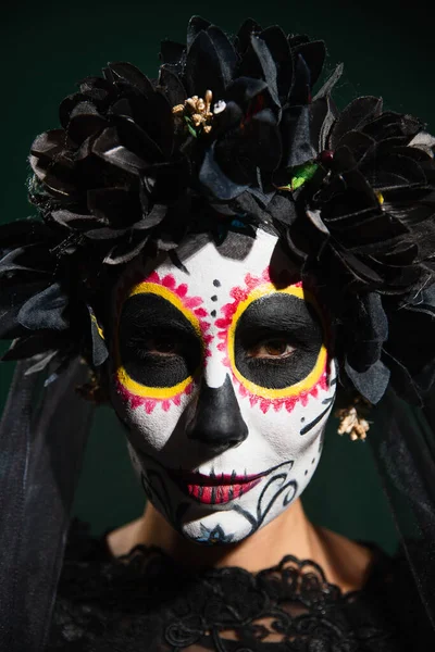 Portrait de femme avec maquillage catrina et fleurs noires sur couronne isolée sur vert foncé — Photo de stock