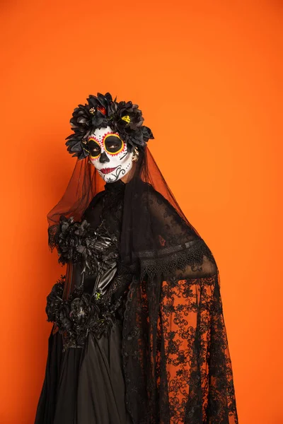 Woman in creepy halloween costume and makeup looking away while posing isolated on orange — Stock Photo