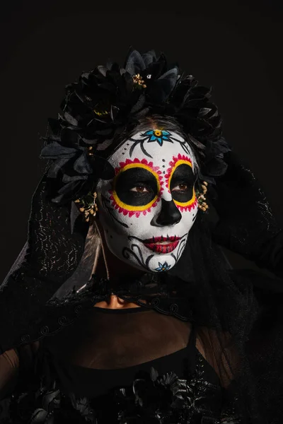 Portrait de femme en couronne noire avec voile et effrayante maquillage du crâne de sucre isolé sur noir — Photo de stock