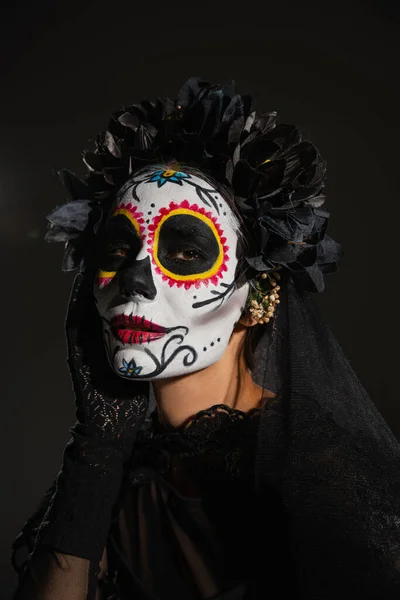 Portrait of traditional mexican day of dead makeup and dark wreath isolated on black — Stock Photo