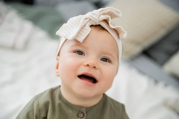 Portrait of happy baby girl in pastel pink headband with bow — Stock Photo