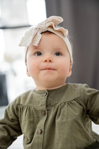 Portrait of cute baby girl in dress and headband with bow — Stock Photo