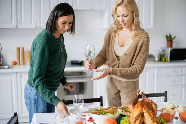 Frauen stellen Teller und Glas bei Erntedankfeier auf den Tisch — Stockfoto