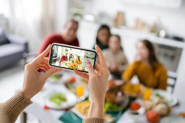 Frau fotografiert multiethnische Familie in der Nähe von Erntedankdinner zu Hause — Stockfoto