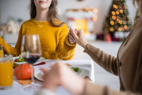Cropped view of mother holding hands of kids near thanksgiving dinner at home — Stock Photo