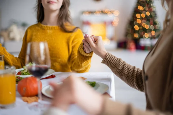 Vue recadrée de la mère tenant la main des enfants près du dîner d'Action de grâces à la maison — Photo de stock