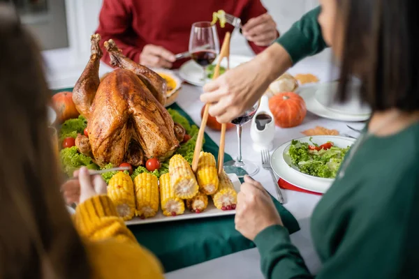 Donna che prende il mais durante la cena del Ringraziamento con la famiglia a casa — Foto stock