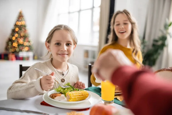 Smiling kid looking at camera near thanksgiving dinner with family at home — Stock Photo