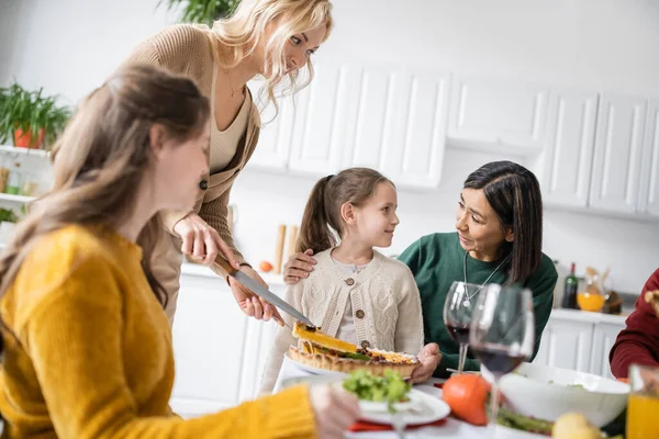 Abuelo multiétnico mirando al niño durante la celebración de Acción de Gracias en casa - foto de stock