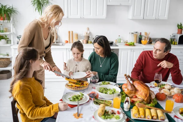 Vielvölkerfamilie feiert Erntedank zu Hause mit Kuchen und Truthahn — Stockfoto