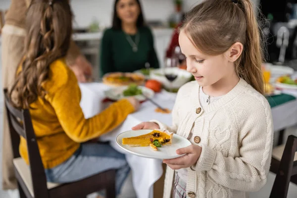 Enfant regardant Thanksgiving tarte tout en célébrant Thanksgiving avec la famille à la maison — Photo de stock