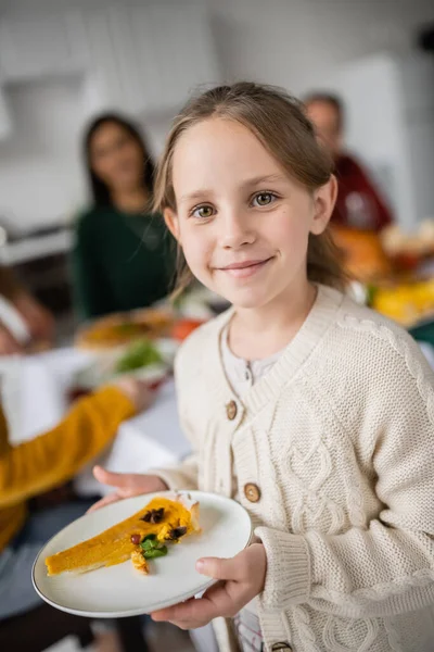 Smiling girl holding thanksgiving pie and looking at camera at home — Stock Photo