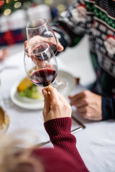 Partial view of blurred man clinking wine glasses with daughter during thanksgiving dinner — Stock Photo